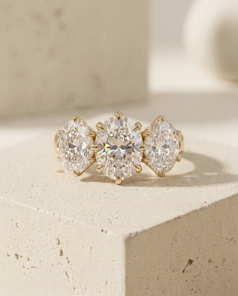 Front view of the oval three stone diamond ring on a pale micro-cement ledge