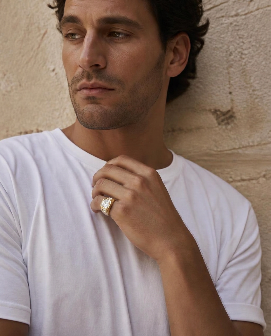 Man in a white T-shirt against cream concrete wearing the RW men's Asscher signet on his pinky finger